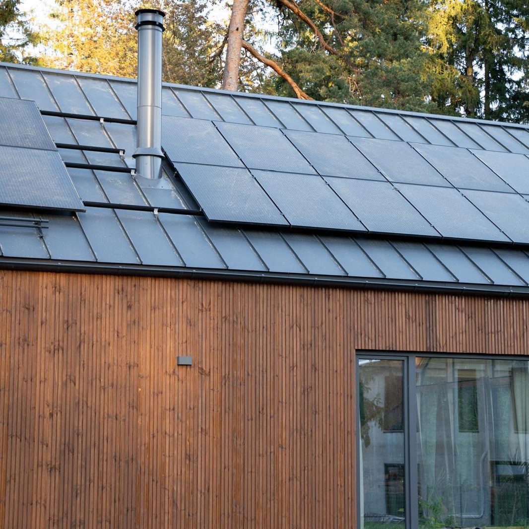 Photovoltaik-Module auf dem Dach eines Light House mit Holzfassade